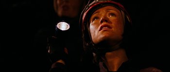 Movie still from “The Descent” (2005), directed by Neil Marshall – A woman with a helmet on holding a flashlight; Close Up shot, Low angle