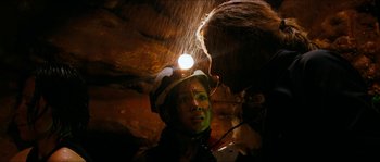 Movie still from “The Descent” (2005), directed by Neil Marshall – A person with a hard hat and a light on his head; Close Up shot, Overhead angle