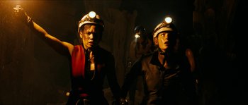 Movie still from “The Descent” (2005), directed by Neil Marshall – A couple of people that are in a cave; Medium shot, High angle
