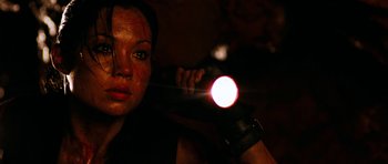 Movie still from “The Descent” (2005), directed by Neil Marshall – A woman holding a flashlight in a dark room; Close Up shot, Low angle
