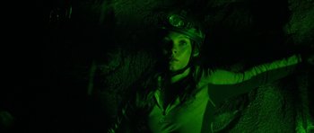 Movie still from “The Descent” (2005), directed by Neil Marshall – A woman wearing a helmet is in a dark cave; Close Up shot, Overhead angle