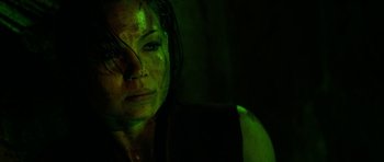 Movie still from “The Descent” (2005), directed by Neil Marshall – A person with green light on their face; Close Up shot, High angle