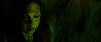 Movie still from “The Descent” (2005), directed by Neil Marshall – A person with green paint on their face; Close Up shot, Overhead angle
