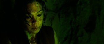 Movie still from “The Descent” (2005), directed by Neil Marshall – A person with green paint on their face; Close Up shot, Overhead angle