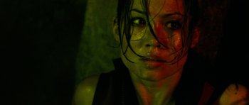 Movie still from “The Descent” (2005), directed by Neil Marshall – A woman's face in a green light; Close Up shot, High angle