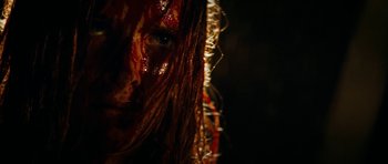 Movie still from “The Descent” (2005), directed by Neil Marshall – The face of a woman with blood on her face; Extreme Close Up shot, Over the shoulder angle