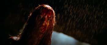 Movie still from “The Descent” (2005), directed by Neil Marshall – A woman with blood all over her face and head; Close Up shot, Low angle