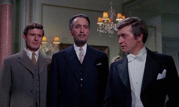 Movie still from “The Devil Rides Out” (1968), directed by Terence Fisher – A group of men standing next to each other in a room; Medium shot, Low angle