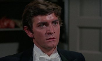 Movie still from “The Devil Rides Out” (1968), directed by Terence Fisher – A person wearing a suit and bow tie; Close Up shot, High angle
