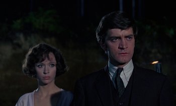 Movie still from “The Devil Rides Out” (1968), directed by Terence Fisher – A man and a woman standing next to each other in front of trees; Close Up shot, Low angle