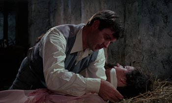 Movie still from “The Devil Rides Out” (1968), directed by Terence Fisher – A man and a woman are sitting on the ground; Close Up shot, Over the shoulder angle