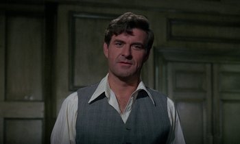 Movie still from “The Devil Rides Out” (1968), directed by Terence Fisher – A person wearing a shirt and vest; Close Up shot, Over the shoulder angle