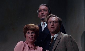 Movie still from “The Devil Rides Out” (1968), directed by Terence Fisher – A group of people standing next to each other; Medium shot, Low angle