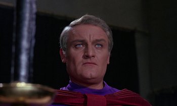 Movie still from “The Devil Rides Out” (1968), directed by Terence Fisher – A person wearing a purple shirt; Close Up shot, Low angle