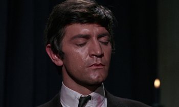 Movie still from “The Devil Rides Out” (1968), directed by Terence Fisher – A person wearing a suit and tie; Close Up shot, High angle