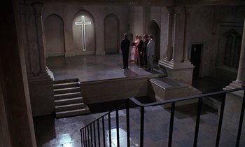 Movie still from “The Devil Rides Out” (1968), directed by Terence Fisher – A group of people standing in front of a cross; Extreme Wide shot, High angle