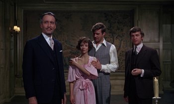 Movie still from “The Devil Rides Out” (1968), directed by Terence Fisher – A group of men and a woman standing next to each other; Medium shot, Over the shoulder angle