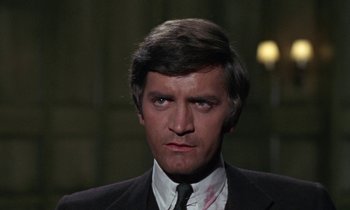 Movie still from “The Devil Rides Out” (1968), directed by Terence Fisher – A person wearing a suit and tie; Close Up shot, High angle