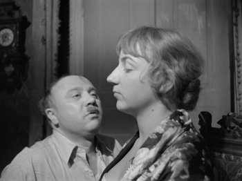 Movie still from “The Devil Strikes at Night” (1957), directed by Robert Siodmak – An old photo of a man and a woman looking at each other; Close Up shot, Over the shoulder angle