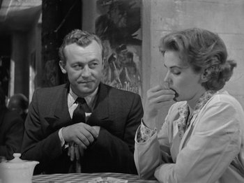 Movie still from “The Devil Strikes at Night” (1957), directed by Robert Siodmak – A man and a woman sitting in front of a table; Medium shot, Over the shoulder angle