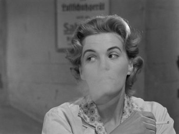 Movie still from “The Devil Strikes at Night” (1957), directed by Robert Siodmak – An old photo of a woman smoking a cigarette; Close Up shot, Over the shoulder angle
