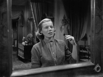 Movie still from “The Devil Strikes at Night” (1957), directed by Robert Siodmak – An old photo of a woman looking in the mirror; Medium shot, Low angle