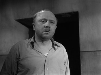 Movie still from “The Devil Strikes at Night” (1957), directed by Robert Siodmak – Black and white photograph of a man in a shirt; Close Up shot, Low angle