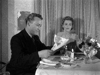 Movie still from “The Devil Strikes at Night” (1957), directed by Robert Siodmak – A man and a woman sitting at a dinner table; Medium shot, Low angle