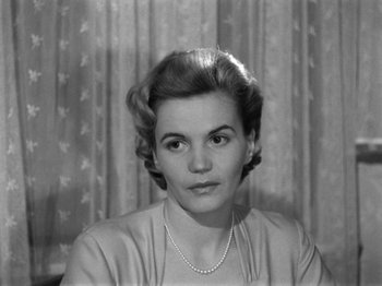 Movie still from “The Devil Strikes at Night” (1957), directed by Robert Siodmak – An old photo of a woman with a necklace in front of a curtain; Close Up shot, High angle