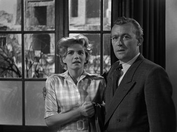 Movie still from “The Devil Strikes at Night” (1957), directed by Robert Siodmak – An old photo of a man and a woman posing for a picture; Medium shot, Low angle