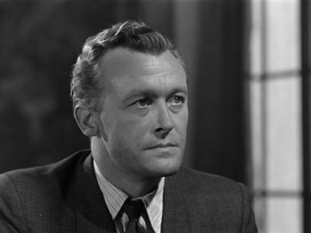 Movie still from “The Devil Strikes at Night” (1957), directed by Robert Siodmak – An old black and white photo of a man in a suit; Close Up shot, Low angle
