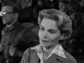 Movie still from “The Devil Strikes at Night” (1957), directed by Robert Siodmak – An old photo of a woman in a trench coat looking to her left; Close Up shot, Over the shoulder angle