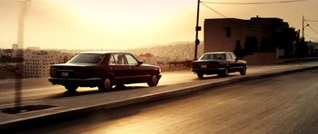 Movie still from “The Devil's Double” (2011), directed by Lee Tamahori – A couple of cars driving down a street; Wide shot, Low angle
