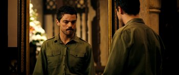 Movie still from “The Devil's Double” (2011), directed by Lee Tamahori – A man looking at himself in the mirror; Medium shot, Over the shoulder angle