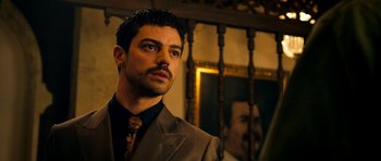 Movie still from “The Devil's Double” (2011), directed by Lee Tamahori – A man wearing a suit and tie in front of a mirror; Close Up shot, Low angle