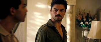 Movie still from “The Devil's Double” (2011), directed by Lee Tamahori – A person wearing a shirt and looking at the camera; Close Up shot, Over the shoulder angle