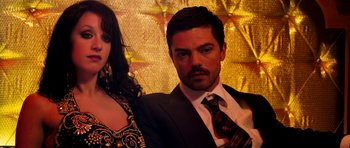 Movie still from “The Devil's Double” (2011), directed by Lee Tamahori – A man and a woman posing for a picture; Close Up shot, Over the shoulder angle