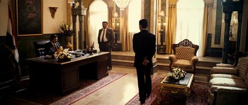 Movie still from “The Devil's Double” (2011), directed by Lee Tamahori – Two men in suits are standing in front of a mirror; Wide shot, Over the shoulder angle