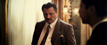 Movie still from “The Devil's Double” (2011), directed by Lee Tamahori – A person wearing a suit and tie; Close Up shot, Low angle