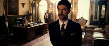 Movie still from “The Devil's Double” (2011), directed by Lee Tamahori – A man in a suit and tie; Medium shot, Low angle