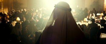 Movie still from “The Devil's Double” (2011), directed by Lee Tamahori – A person with a veil in front of a group of people; Medium shot, Over the shoulder angle