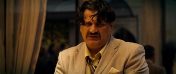 Movie still from “The Devil's Double” (2011), directed by Lee Tamahori – A person wearing a suit and tie; Close Up shot, Over the shoulder angle