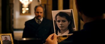 Movie still from “The Devil's Double” (2011), directed by Lee Tamahori – A person holding up a picture of a woman; Close Up shot, Over the shoulder angle