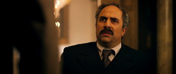 Movie still from “The Devil's Double” (2011), directed by Lee Tamahori – A person wearing a suit and tie; Close Up shot, Low angle