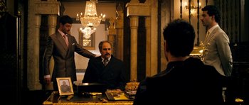 Movie still from “The Devil's Double” (2011), directed by Lee Tamahori – A man in a suit and tie sitting in front of a mirror; Medium shot, Over the shoulder angle