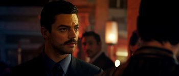 Movie still from “The Devil's Double” (2011), directed by Lee Tamahori – A person wearing a suit and tie; Close Up shot, Over the shoulder angle