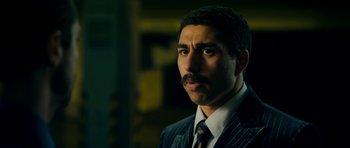 Movie still from “The Devil's Double” (2011), directed by Lee Tamahori – A person wearing a suit and tie; Close Up shot, Low angle