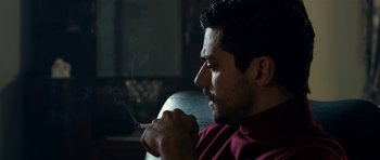 Movie still from “The Devil's Double” (2011), directed by Lee Tamahori – A person sitting with a cigarette in his mouth; Close Up shot, Over the shoulder angle