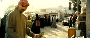 Movie still from “The Devil's Double” (2011), directed by Lee Tamahori – A group of people walking down a street; Medium shot, Over the shoulder angle