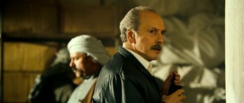 Movie still from “The Devil's Double” (2011), directed by Lee Tamahori – A man with a mustache and a beard; Close Up shot, Over the shoulder angle